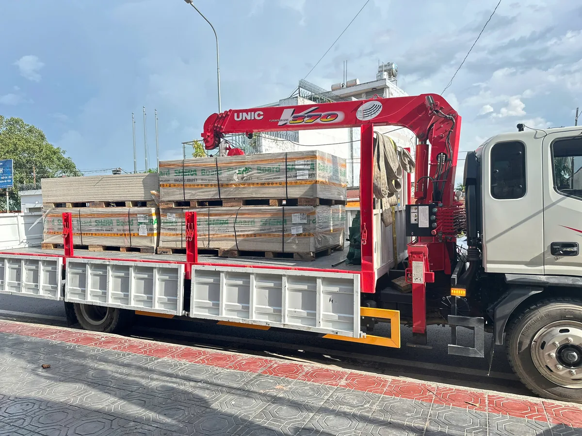 Xe tải gắn cẩu giao hai pallet tấm Sheraboard chính hãng tới công trình nhà phố