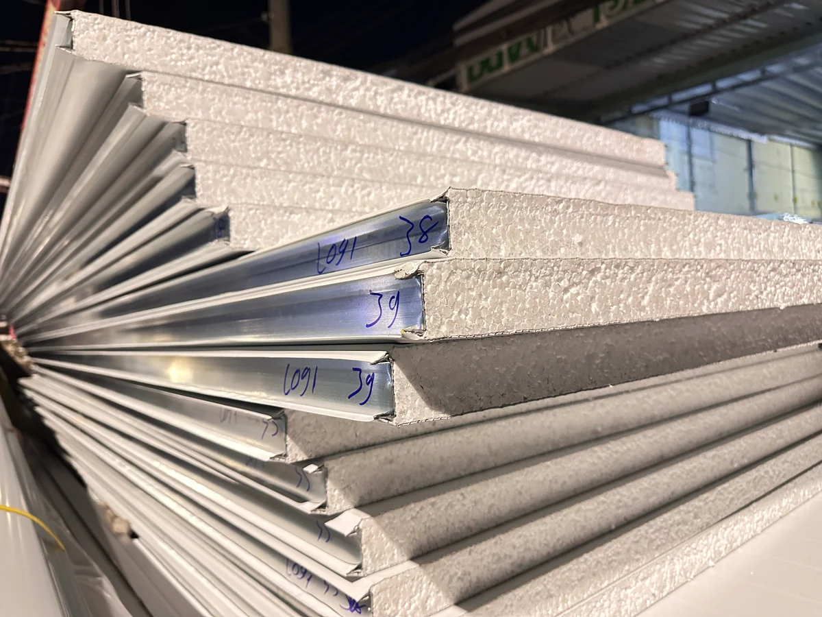 Cận cảnh mép tấm panel lõi EPS trắng với ngàm âm dương và hai lớp tôn